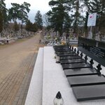 Aleja na cmentarzu. Po lewej zbiorowa mogiła Żołnierzy Wojska Polskiego. Na szarej długiej płucie umieszczone  nagrobki z małymi krzyżami